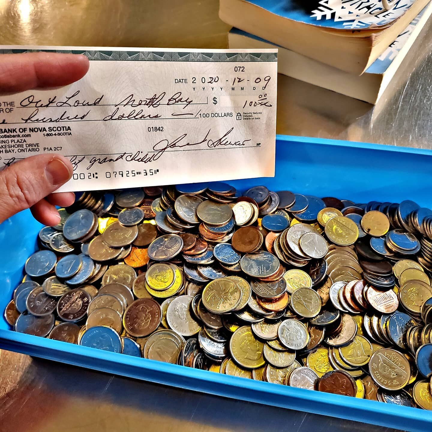 A photo of a donation check and a container of coins